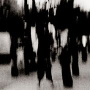 Schwarzweißaufnahme: eine Radfahrerin unterwegs auf der Schönhauser Allee, verschwommen, im Hintergrund die U-Bahn.